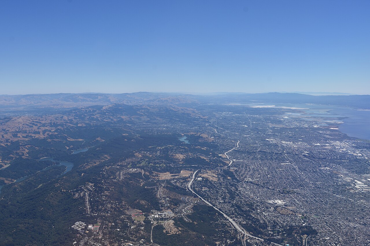 丘陵の住宅地と市街地、湾を上空から見たオークランド
